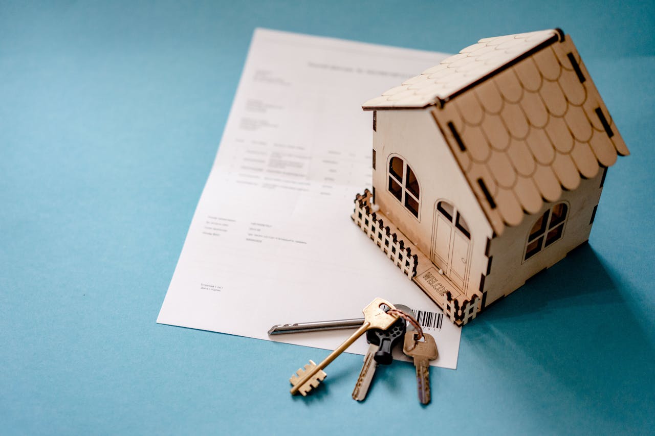 The Art of Drawing Readers In: Your attractive post title goes here Miniature wooden house with keys and contract symbolizing real estate transactions.