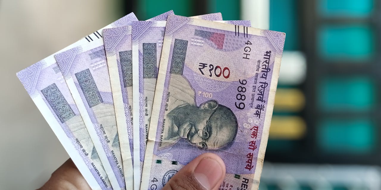 Mastering the First Impression: Your intriguing post title goes here Close-up view of holding Indian 100 rupee banknotes, showcasing currency details and design.